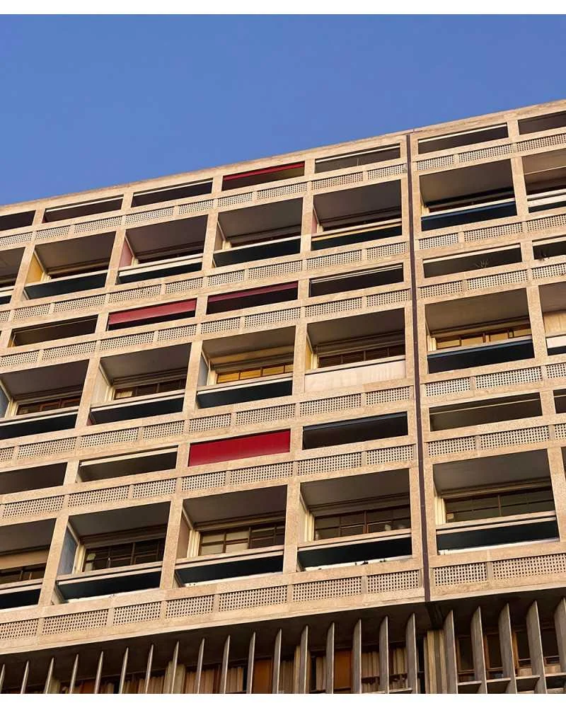 La façade de la Cité Radieuse de Le Corbusier, ses loggias colorées sous un ciel bleu.